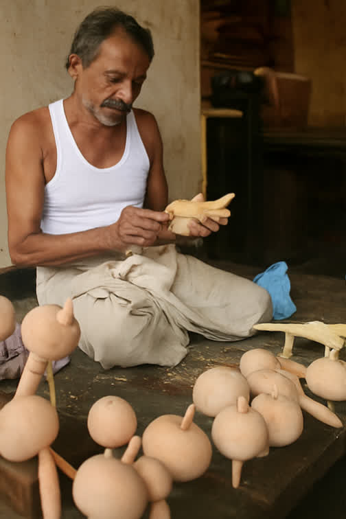 Sawantwadi artisan painting traditional wooden toys by hand in a workshop