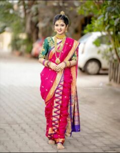 Woman stepping into a pink saree in the classical dhoti style