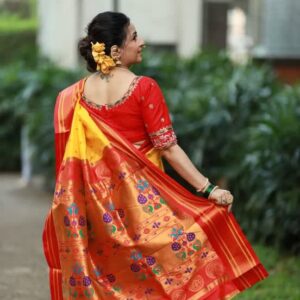 Close up of paithani silk fabric showcasing traditional motifs and shimmering golden borders.