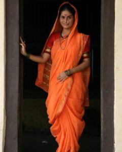 A woman wearing a simple cotton nauvari saree for everyday life among rural and working class women.